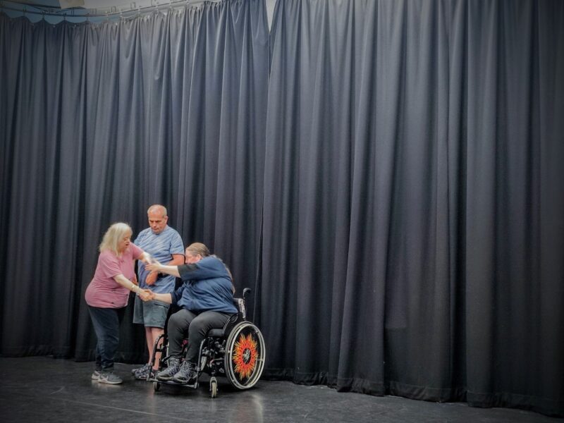 http://Three%20artists%20are%20in%20a%20curtained%20rehearsal%20room.%20They%20are%20in%20motion%20-%20their%20arms%20and%20hands%20connecting.