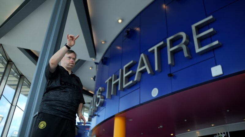 http://An%20Uncurbed%20artist%20is%20performing%20a%20movement%20piece%20in%20The%20Lowry%20Theatre.%20The%20backdrop%20is%20impressive%20with%20the%20word%20'Theatre'%20emblazoned%20across%20an%20electric%20blue%20wall.%20The%20performer%20is%20moving,%20focusing%20on%20his%20hand%20and%20fingers,%20the%20movement%20piece%20is%20precise%20and%20intricate.