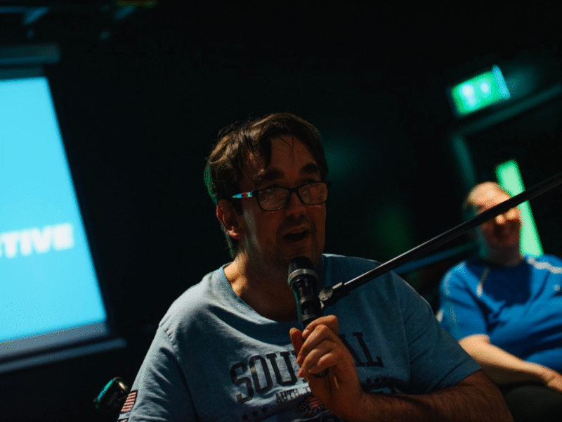 A photo of Phillip Breadney, speaking into a microphone