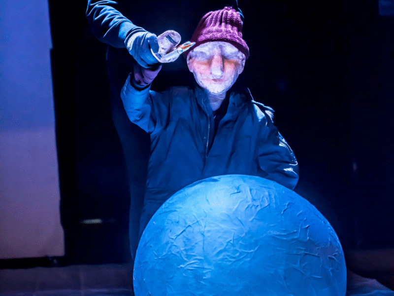 http://A%20photo%20of%20a%20puppet,%20lit%20by%20theatre%20lights,%20touching%20a%20moon%20-%20an%20image%20from%20'Christmas%20with%20the%20Cratchits'